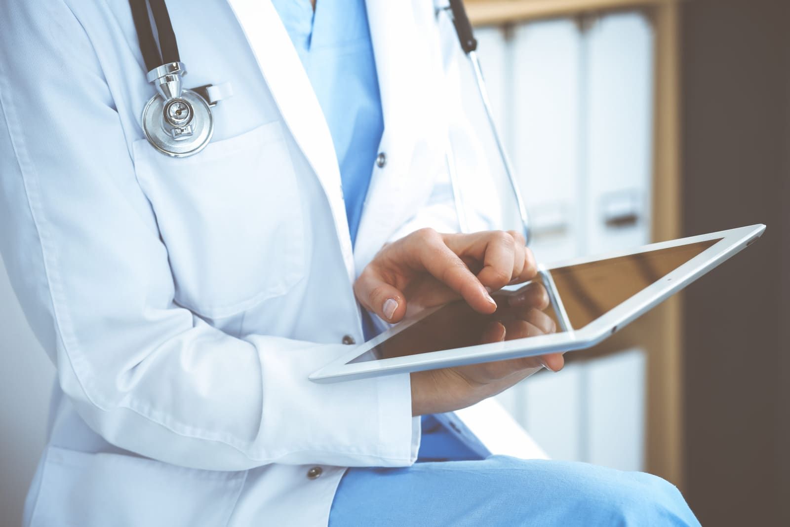Médecin consultant un dossier patient sur tablette
